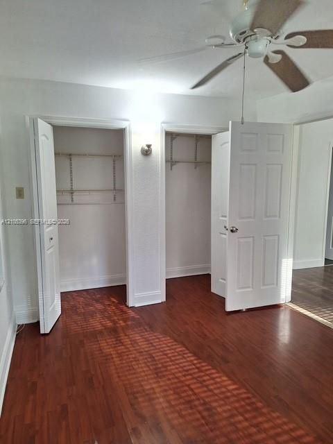 Recessed closets with wire shelving, wood-finish flooring, ceiling fan with light fixture