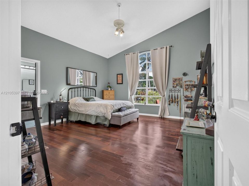 Vaulted ceilings, laminate flooring, and a floor-to-ceiling arched window and direct access to the sun room.