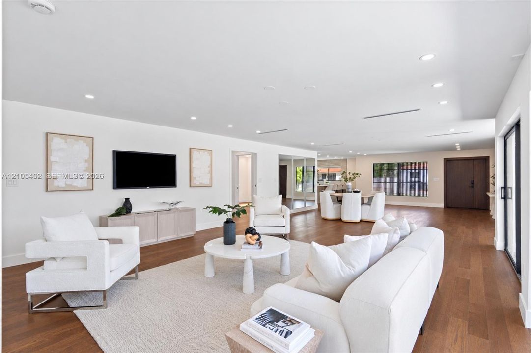 Open-concept floor plan featuring wood-finish flooring, recessed lighting, neutral interior palette, and sliding glass doors