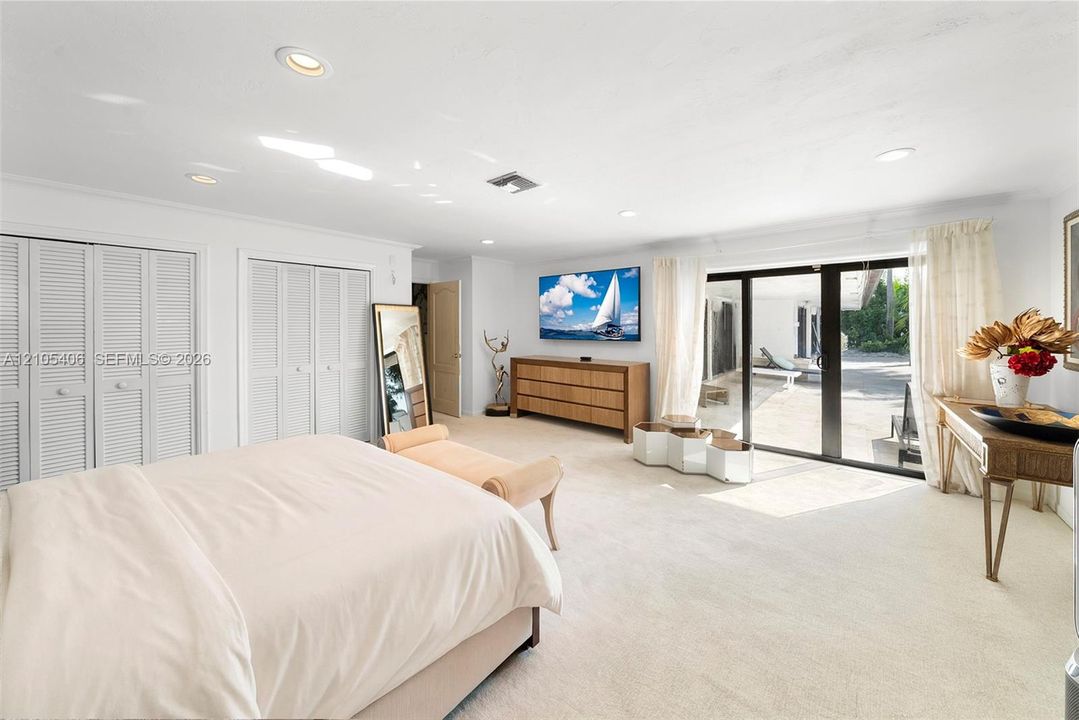 Wall-to-wall carpeting, recessed lighting, louvered closet doors, and direct outdoor access through glass sliding doors