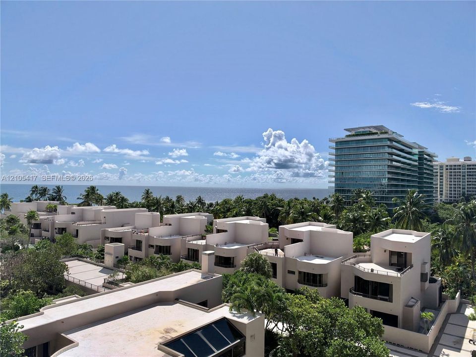Modern low-rise buildings with multiple balconies, surrounded by lush tropical landscaping