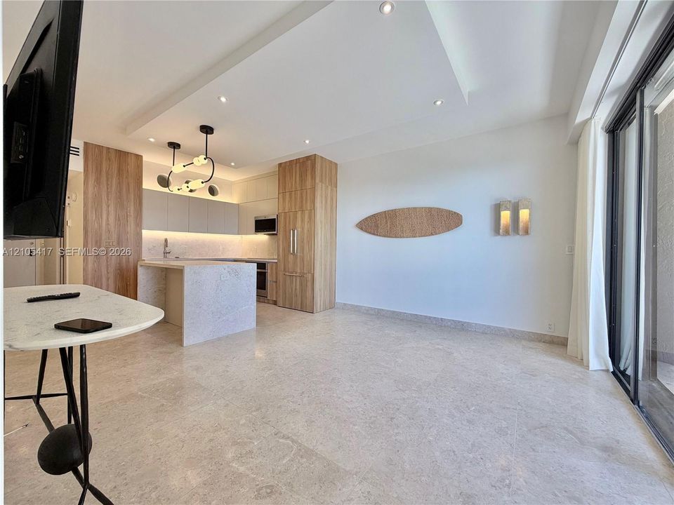 Open-concept living space with light-toned flooring, recessed lighting, and a modern kitchen