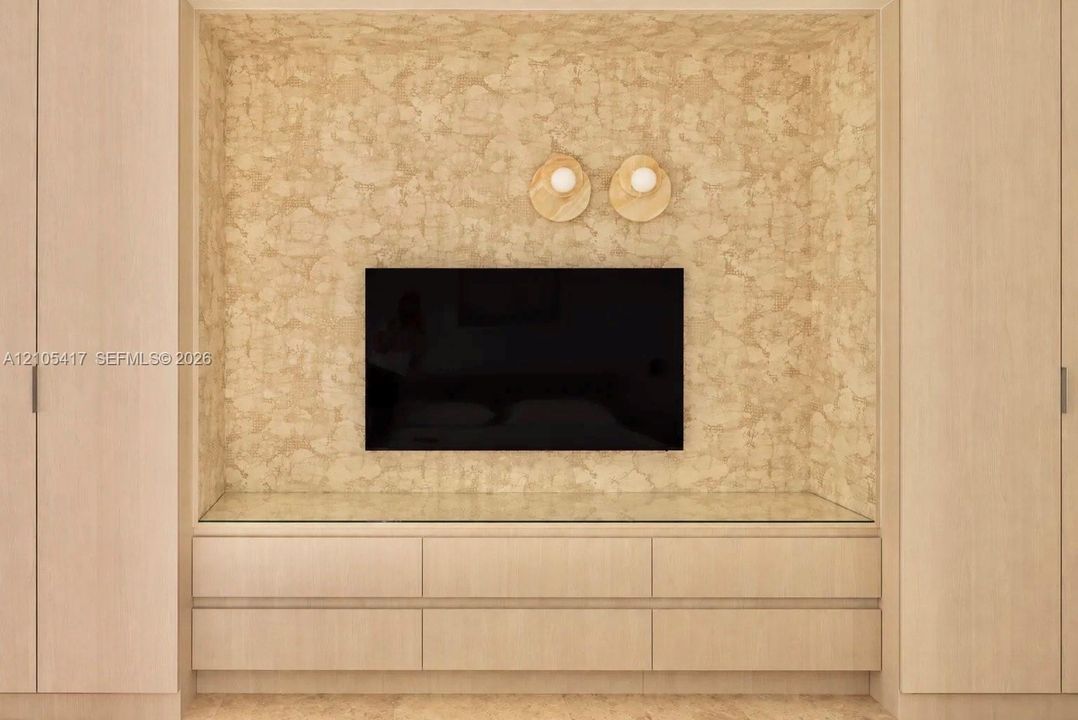 Integrated entertainment center with textured wall finish, wood-finish cabinetry, and glass countertop