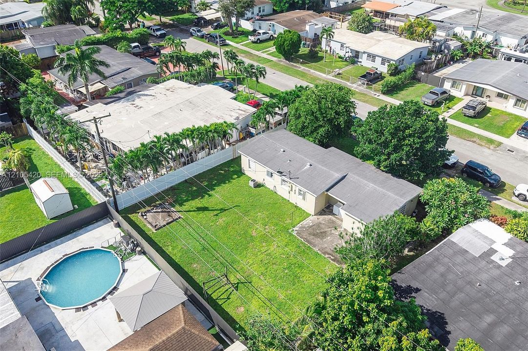 Expansive grass yard with mature trees and perimeter fencing