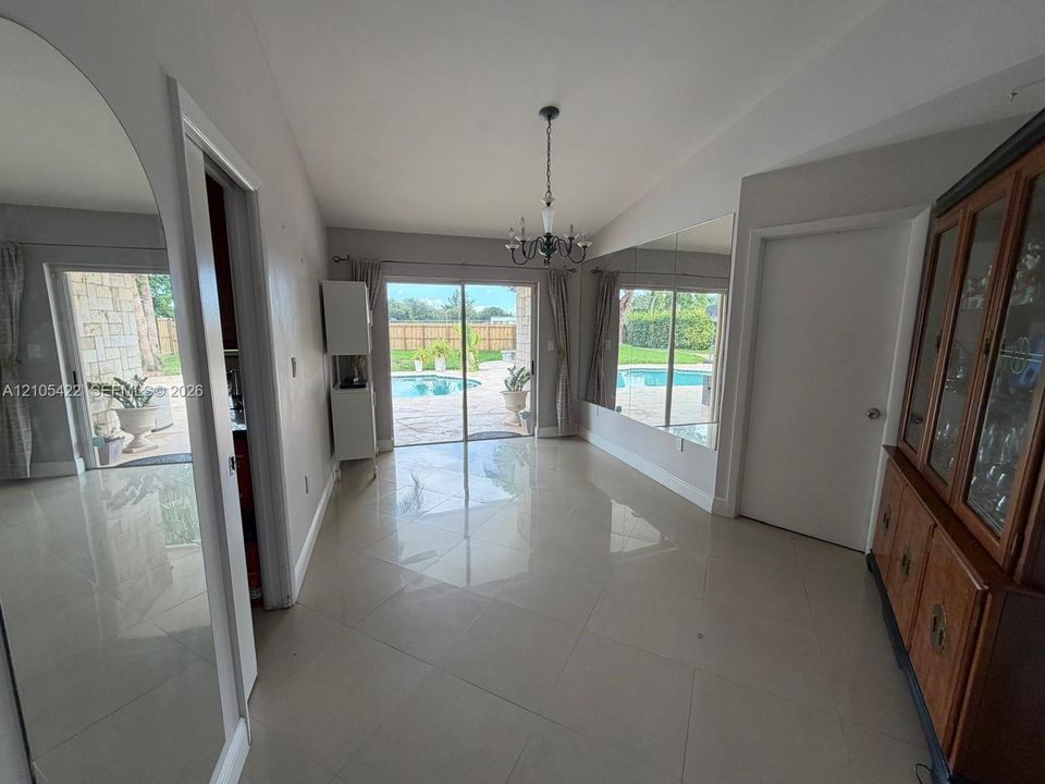 Large-format tile flooring, oversized wall-mounted mirrors, and sliding glass doors with direct exterior access to a paved pool area