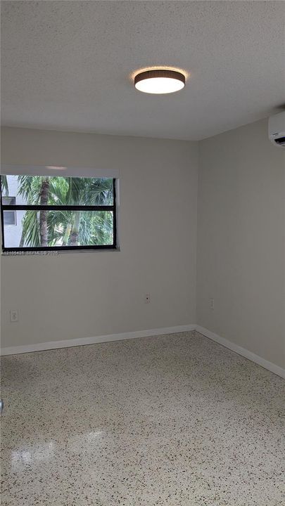 Recessed lighting, window with exterior foliage, and terrazzo flooring