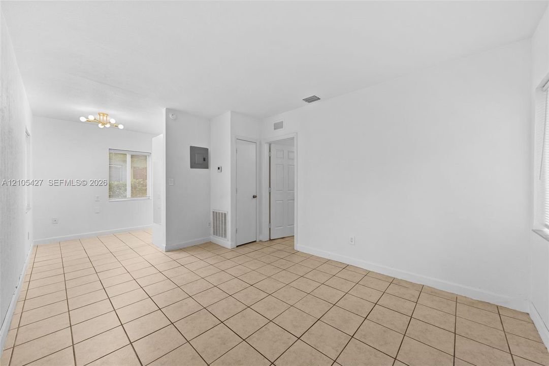 Expansive tile flooring, bright white walls, and a recessed ceiling light fixture