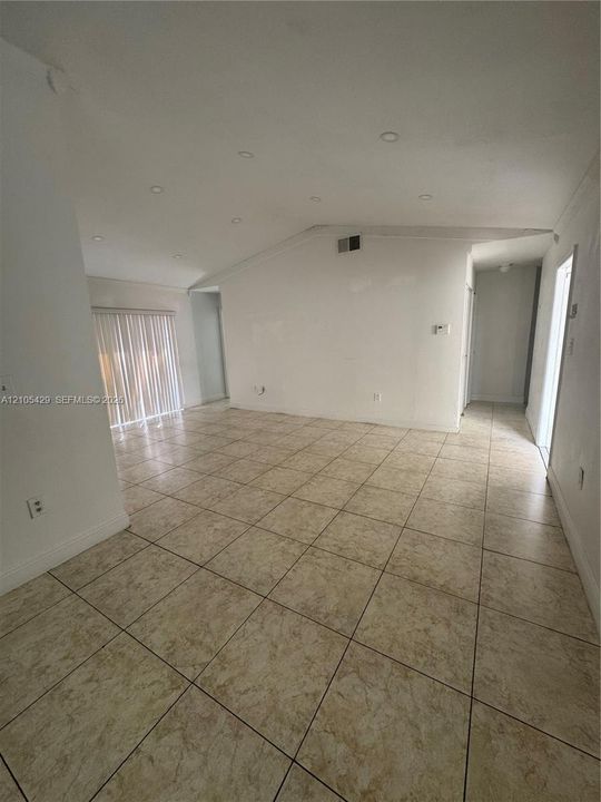 Spacious interior featuring tile flooring, white walls, recessed lighting, and crown molding