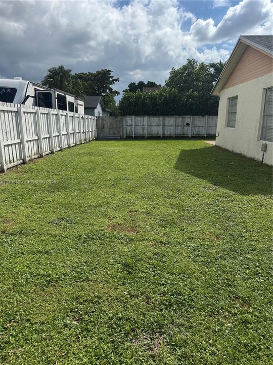 Fenced yard featuring a green lawn