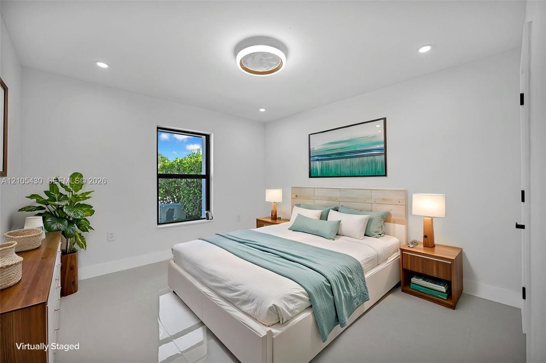 Neutral-toned interior featuring recessed lighting, a contemporary circular flush-mount ceiling fixture, a rectangular window with a black frame, and uniform matte-finish flooring