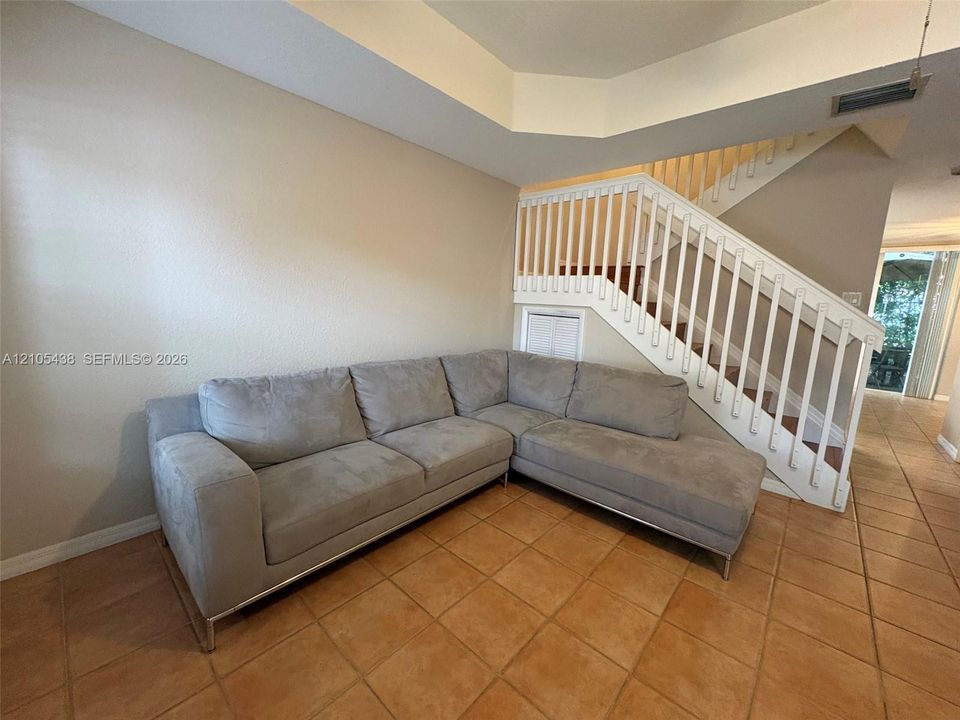 Staircase with white balusters and wood treads, accented by a built-in storage compartment