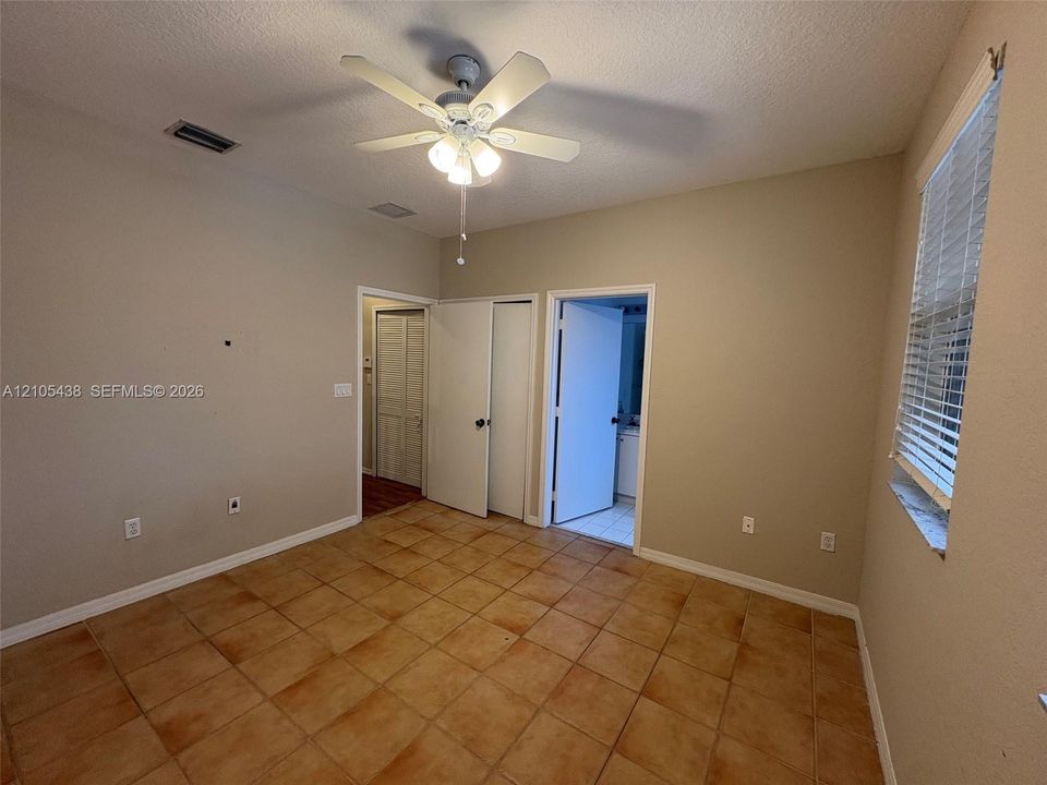 Tile flooring, ceiling fan with integrated lighting, window with blinds, and white trim