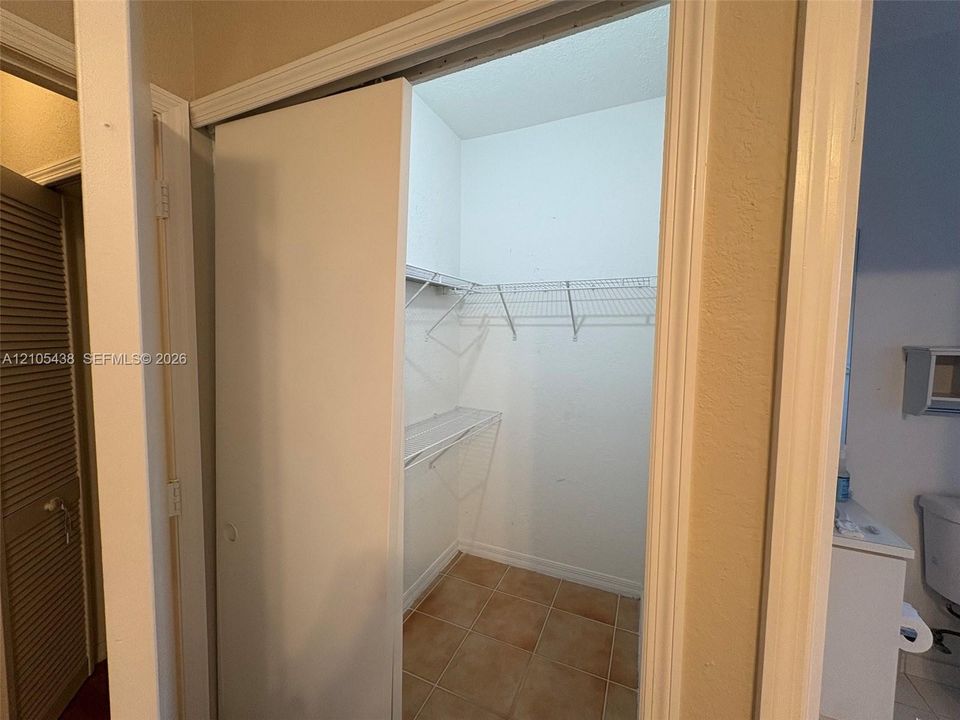 Closet with wire shelving system and terracotta-style floor tiling