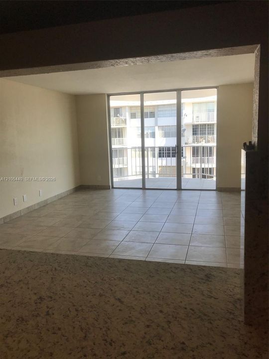 Expansive living space featuring light-toned tile flooring and neutral wall finishes