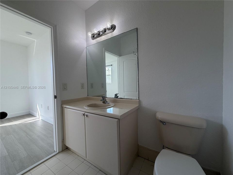 Vanity with integrated sink, two-door cabinetry, and an overhead light bar