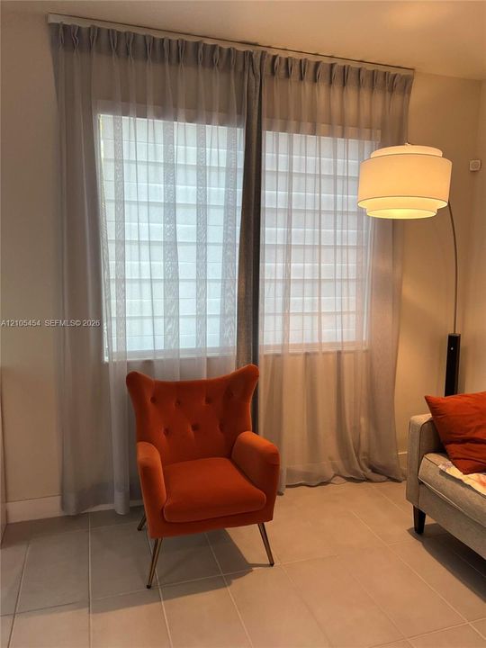 Dual windows with sheer privacy shades and full-length drapery