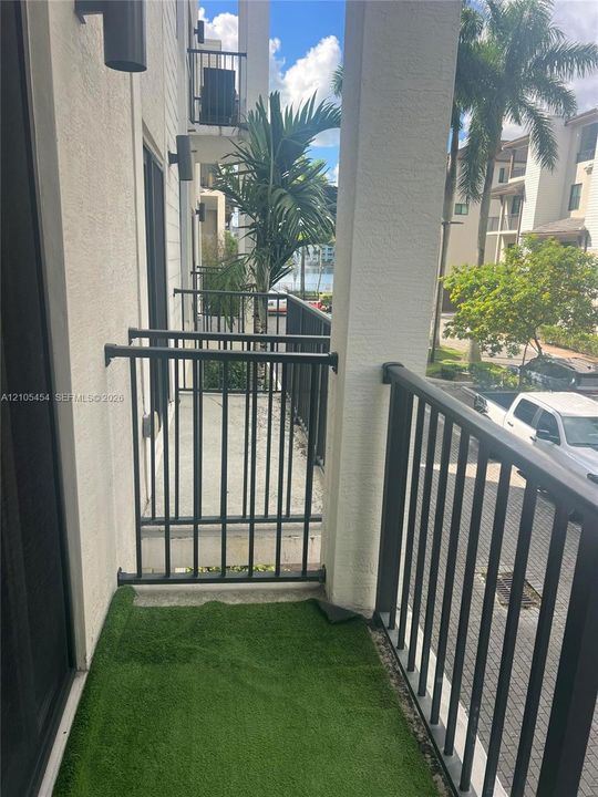 Balcony with metal railings, outdoor wall sconces, and a partial water scene
