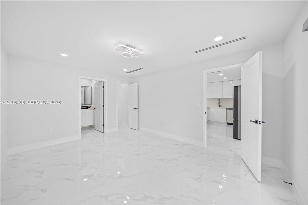 White tile flooring, recessed lighting, modern ceiling light fixture, white walls, white interior doors