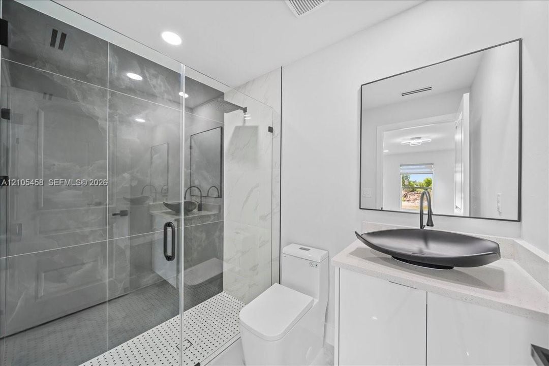 Glass-enclosed shower with large format tile surround