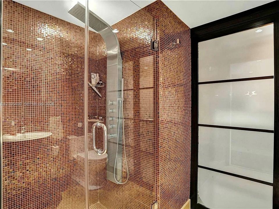 Walk-in shower with full glass enclosure, floor-to-ceiling mosaic tile, multi-function shower panel, and recessed lighting