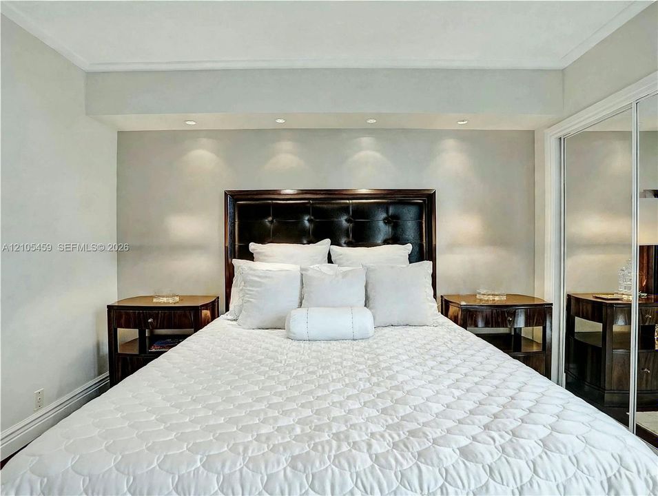 Recessed lighting, crown molding, wood-finish flooring, mirrored closet doors, and a built-in headboard