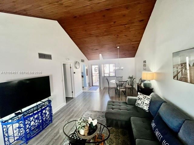 Vaulted wood-paneled ceiling, light wood-finish flooring, and white painted walls