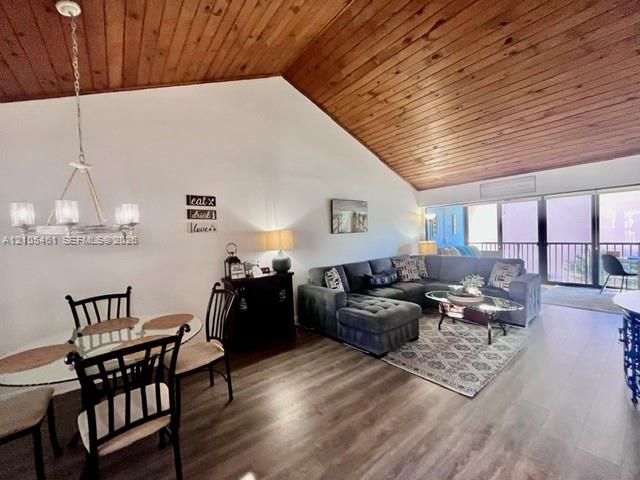 Vaulted wood-paneled ceiling, wood-finish flooring, and glass sliding doors leading to an outdoor balcony