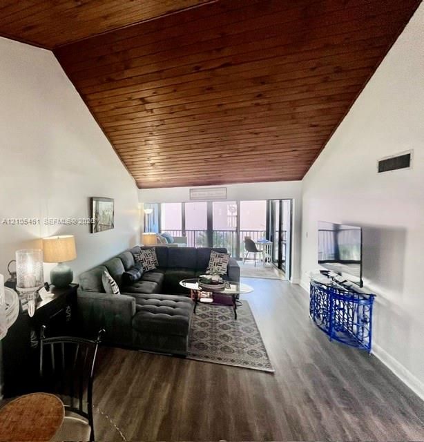 Vaulted wood-plank ceiling, wood-finish flooring, and expansive glass doors leading to a balcony