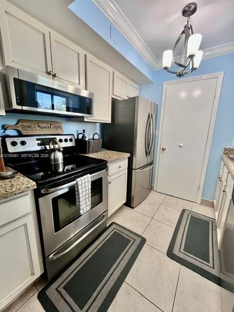 Kitchen featuring stainless steel appliances, light-toned cabinetry, granite-style countertops, and a tiled floor