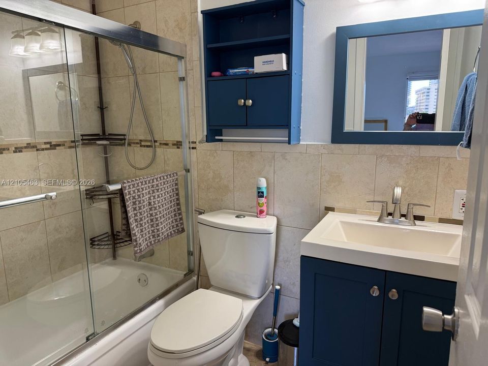 Bathroom featuring a white vanity with integrated sink, chrome faucet, and a blue cabinet base