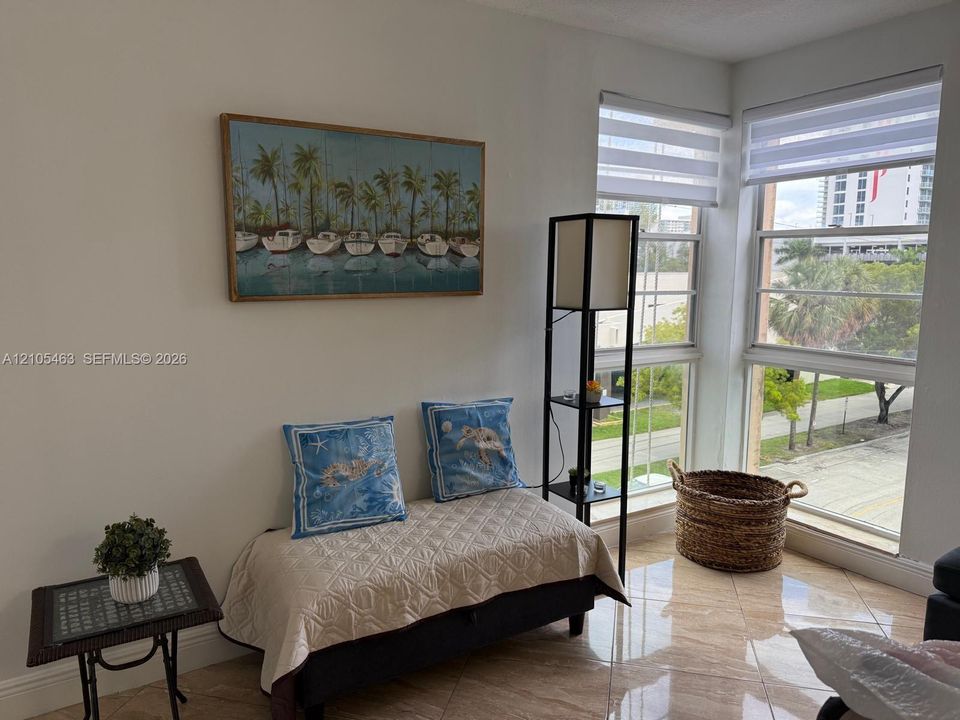 Corner windows with horizontal blinds, providing natural light, and tile flooring