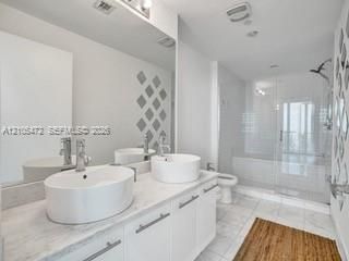 Dual vessel sinks with chrome fixtures set into a light-toned countertop
