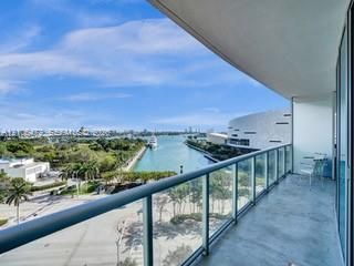 Balcony with a glass railing, concrete flooring, and water scenery