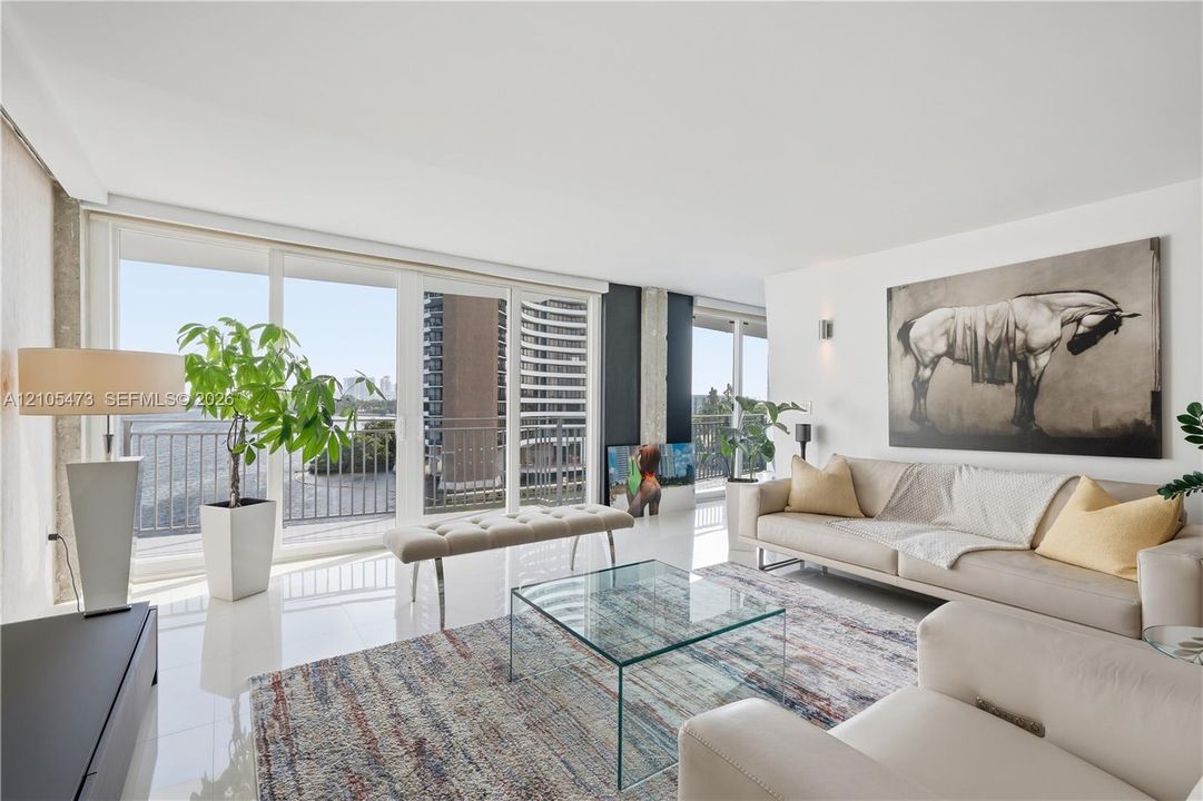 White high-gloss flooring, extensive sliding glass doors, balcony access, recessed lighting, and wall-mounted sconces