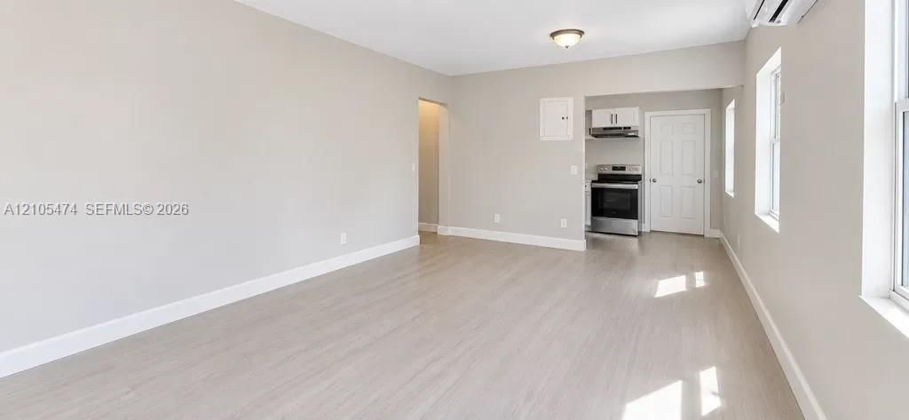 Open-concept living area featuring wood-finish flooring, recessed lighting, and ample natural light through multiple windows