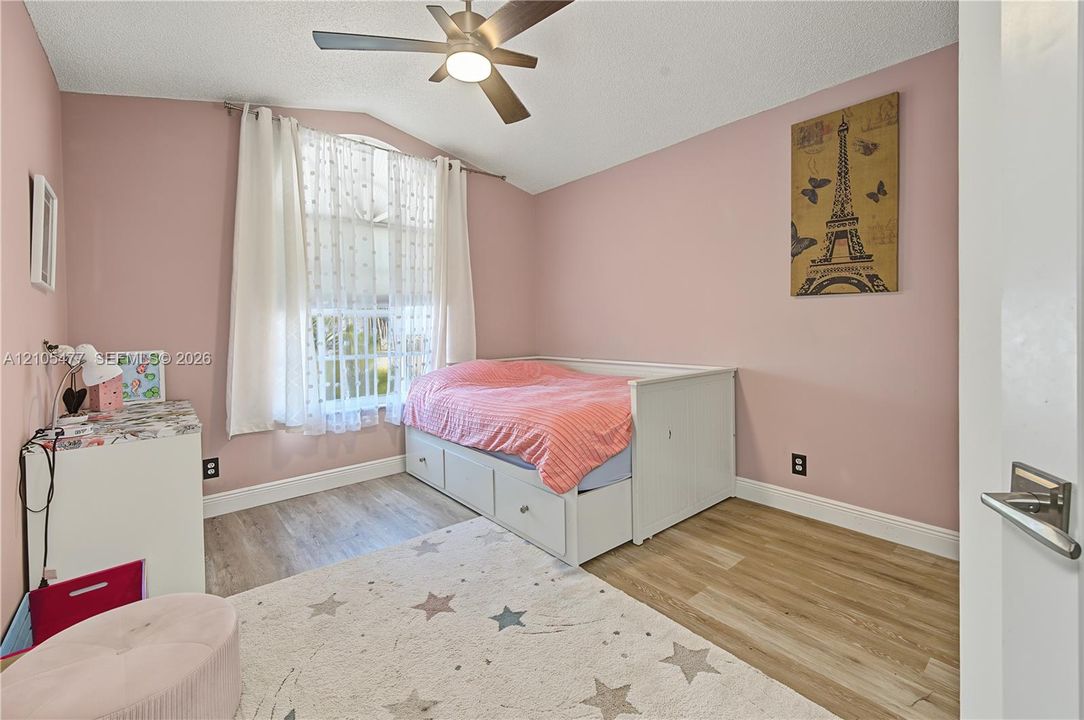 Window with white blinds, wood-finish flooring, ceiling fan with integrated lighting, white baseboards, and a white interior door