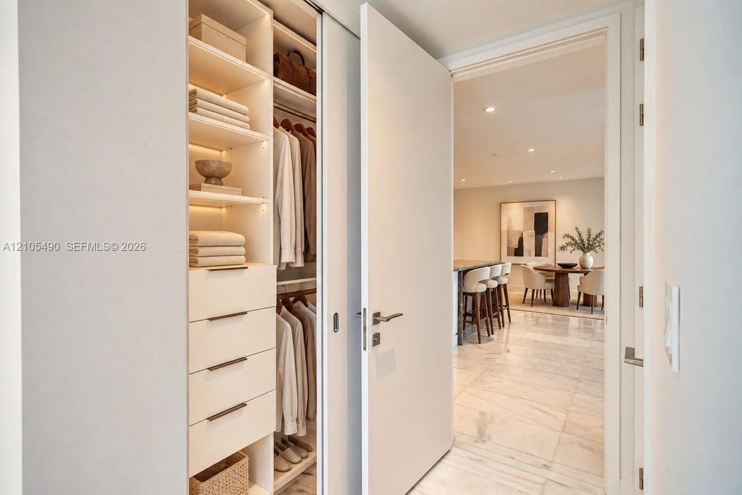Custom built-in closet featuring integrated shelving, soft-close drawers with metallic pulls, and recessed lighting