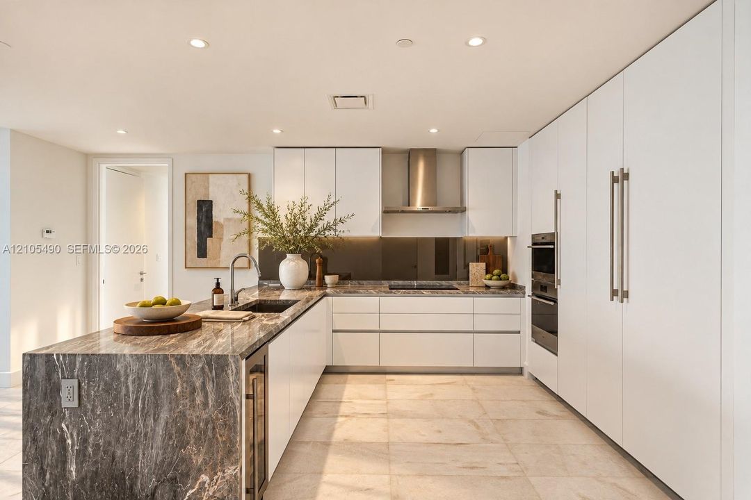 Kitchen featuring flat-panel white cabinetry, stone-patterned countertops, integrated stainless steel appliances, a stainless steel range hood, and tile flooring