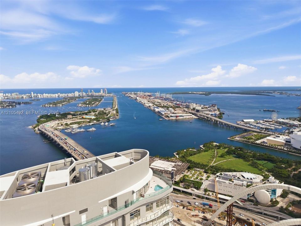 High-rise balcony featuring a glass railing and unobstructed panoramic water and urban harbor scenery