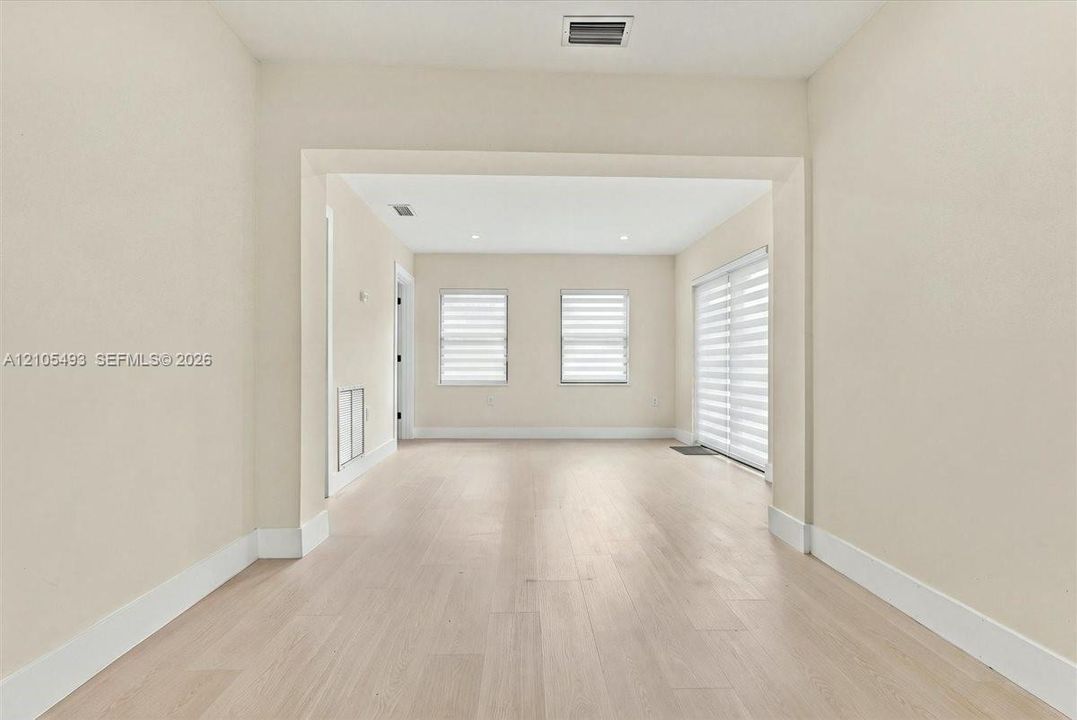 Interior space featuring wood-finish flooring, recessed lighting, and multi-paned windows with horizontal blinds