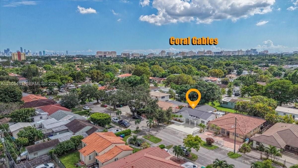 Aerial perspective of a property in a residential setting featuring mature landscaping and a paved driveway