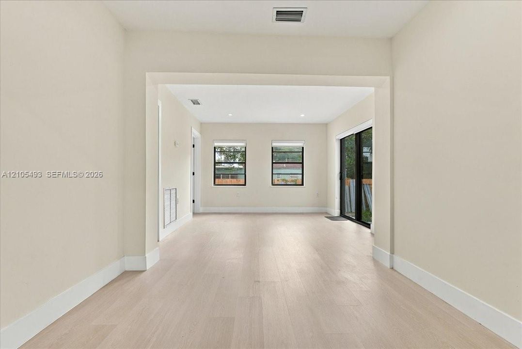 Interior space featuring wood-finish flooring, recessed lighting, and sliding glass doors with black frames