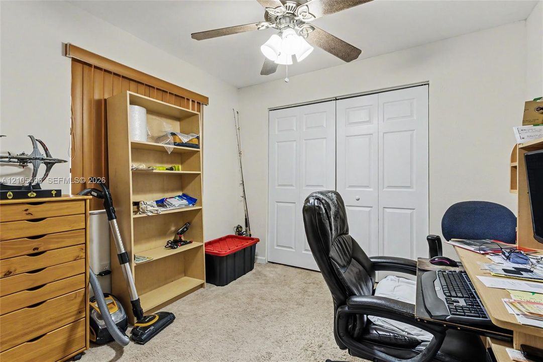 Room featuring neutral wall-to-wall carpeting, a ceiling fan with integrated lighting, and dual-panel closet doors