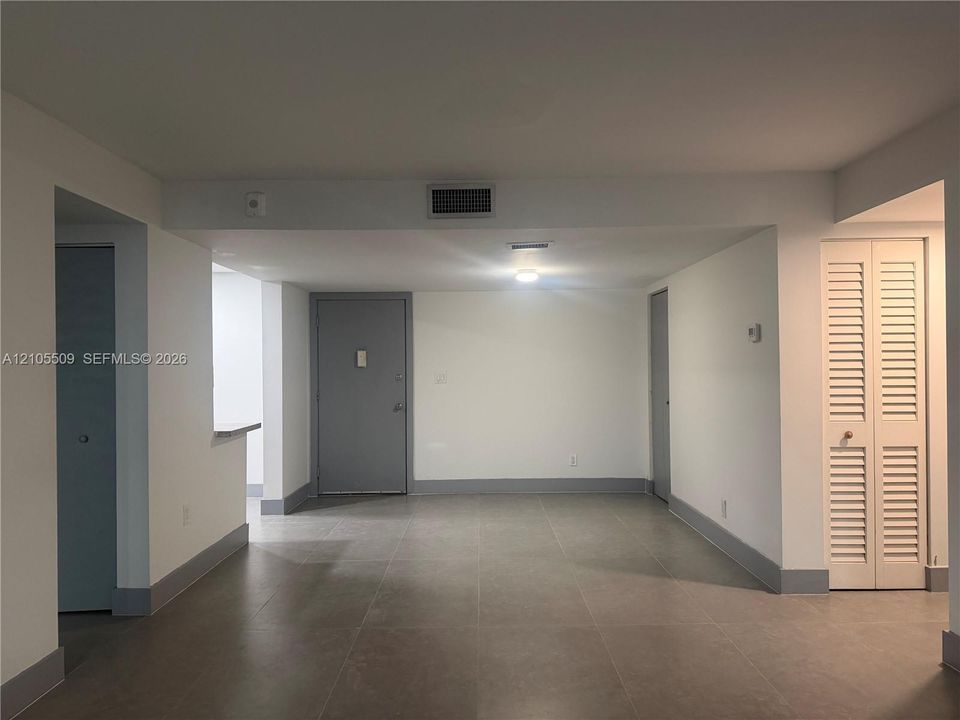 Tiled flooring throughout, white walls, and white louvered bifold doors