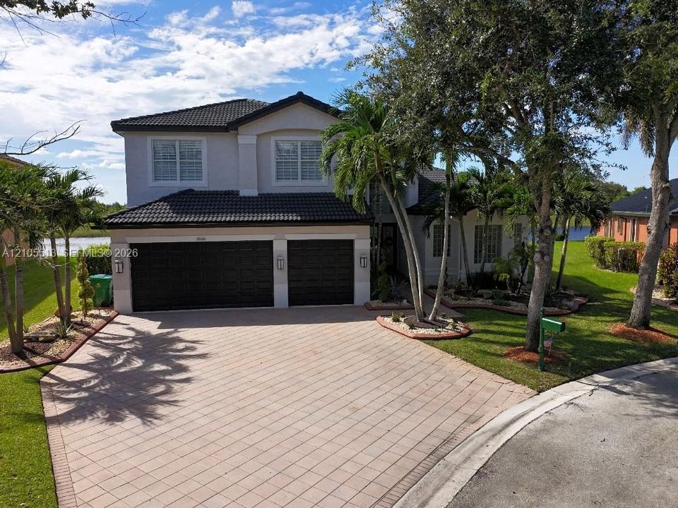 Two-story residence featuring a tile roof and a 3-car garage w/driveway parking for 6 cars
