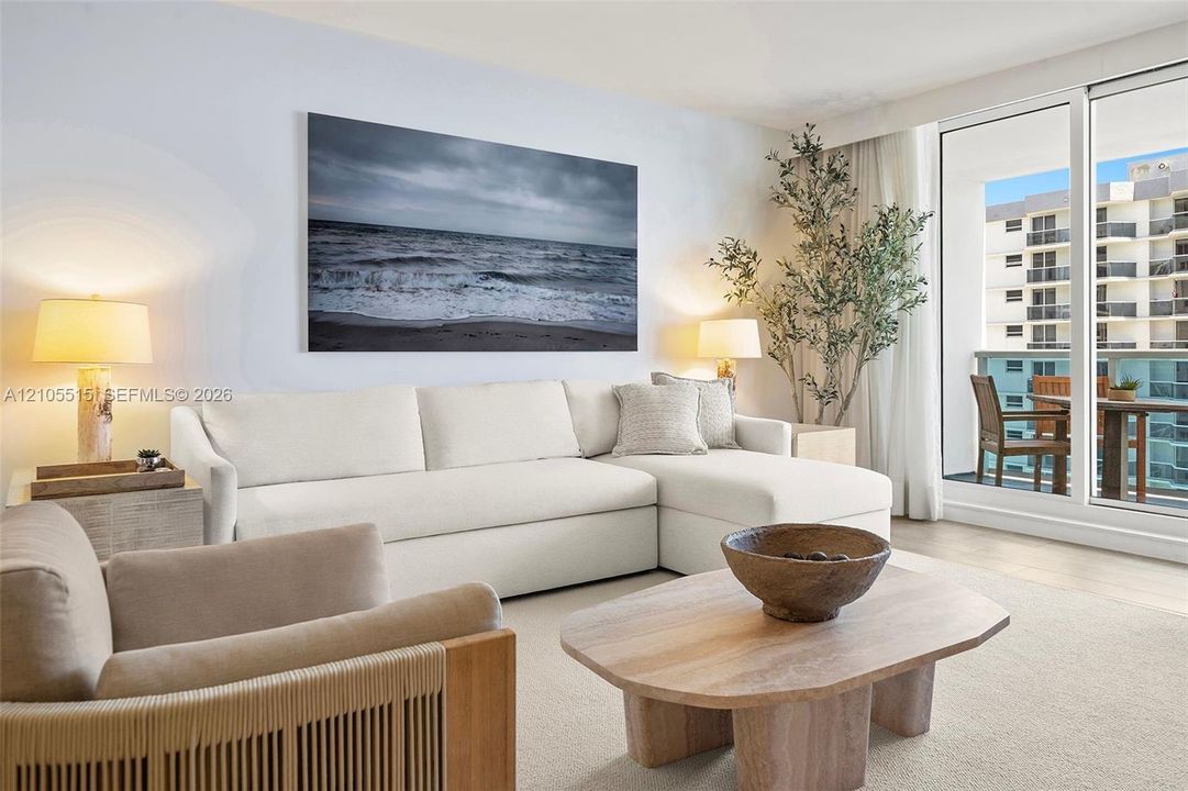 Living area featuring expansive floor-to-ceiling glass sliding doors and neutral-toned textile flooring