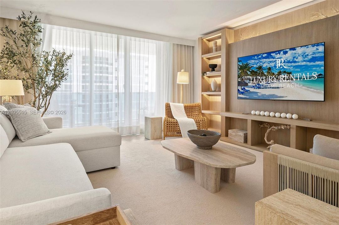Living area featuring floor-to-ceiling windows, custom built-in wood cabinetry with integrated lighting, and neutral carpeting