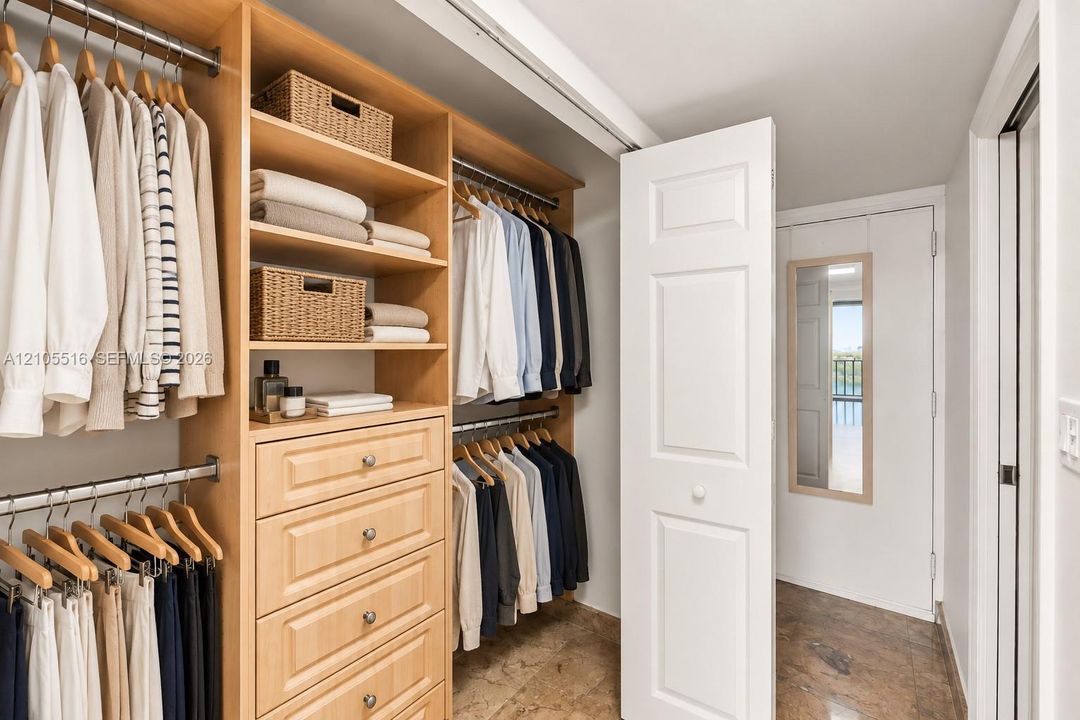 Custom closet system featuring natural wood-finish cabinetry, built-in shelving, and multiple hanging rods