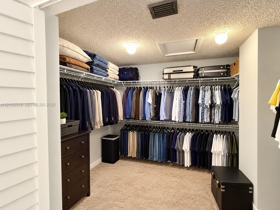 Walk-in storage space featuring multi-level wire shelving and wall-to-wall carpeting