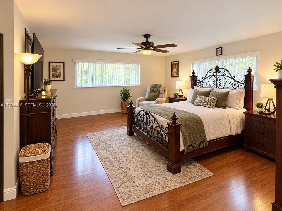 Expansive room featuring wood-finish flooring, horizontal blinds, and an integrated ceiling fan